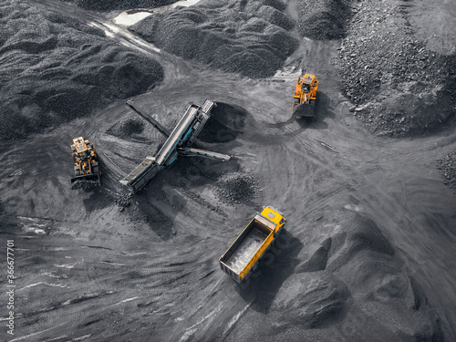 Open pit mine industry, big yellow mining truck for coal, top view aerial drone