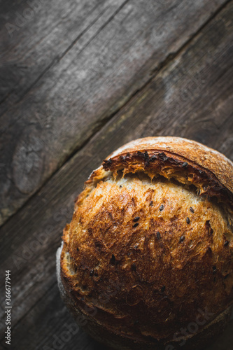 loaf of bread with sesame seeds on wooden background