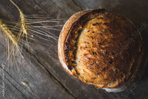 loaf of bread with sesame seeds on wooden background