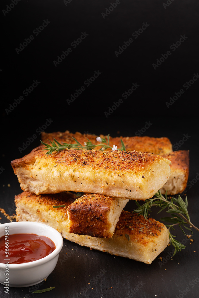 Food appetizer ideas for party concept homemade organic garlic bread stick on black slate board with copy space Food appetizer ideas for party concept homemade organic garlic bread stick on black slate board with copy space