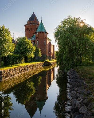 Hjularöd castle relfecting in the moat surrounding it during golder hour photo