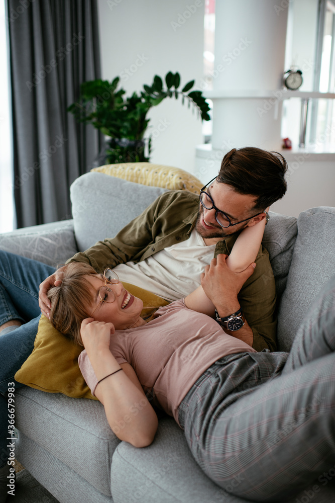 Husband and wife enjoying on sofa. Happy couple relaxing in living room. Husband and wife enjoying on sofa. Happy couple relaxing in living room.