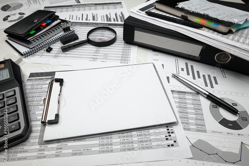 business office desk closeup - financial reports, analysis and accounting, set of documents, tables and graphs, various items for bookkeeping, calculator