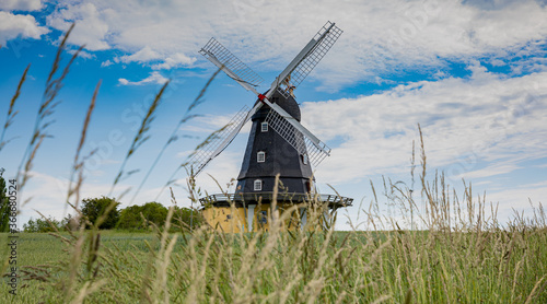 old wind mill in denmark with a field
