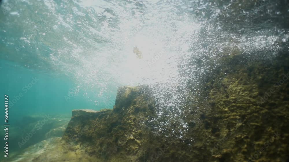 Old stone stairs under water. Waves fall into the water. Beautiful view. 
The camera goes under water. Video recorded in slow motion. 
