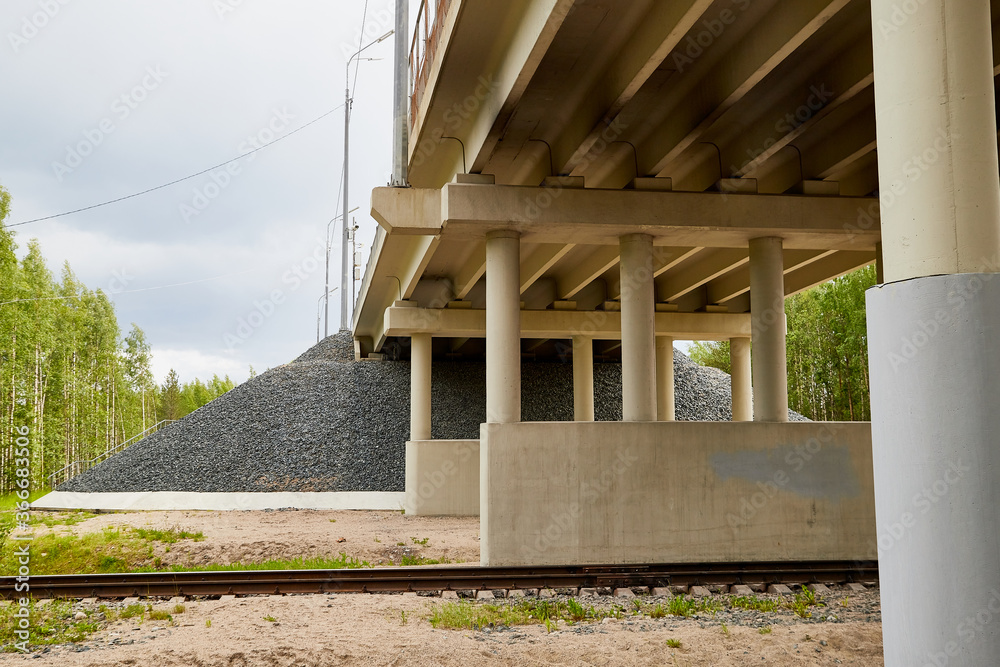 Fototapeta premium Bottom view of the prestressed concrete beams and piers of bridge crossing many-lane expressway of road.