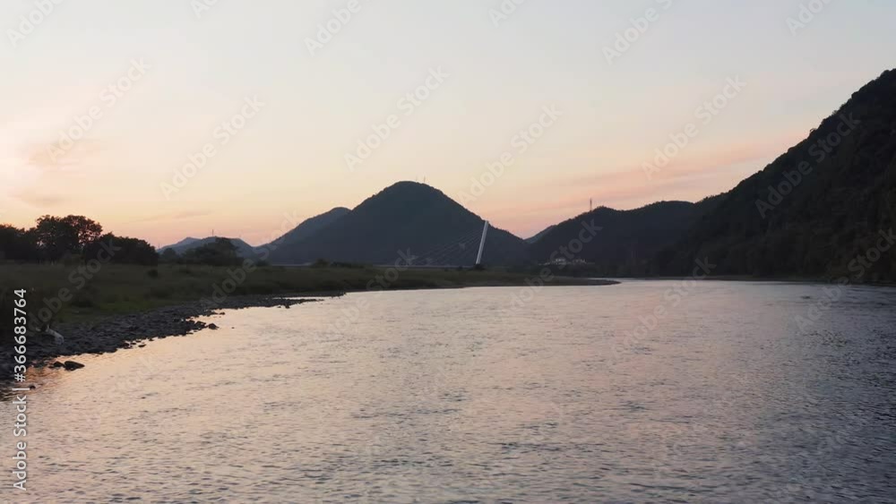 Flowing Gifu Nagara river in Japan at sunrise, slowly floating upstream Flowing Gifu Nagara river in Japan at sunrise, slowly floating upstream