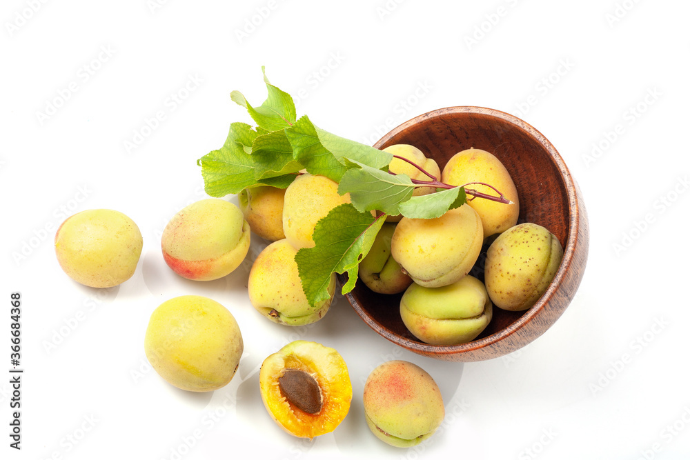 Fresh ripe apricots in wooden bowl isolated on a white background.