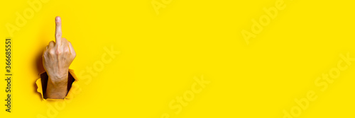 Man's hand showing middle finger, fuck on a yellow background. Hand gestures. Banner.