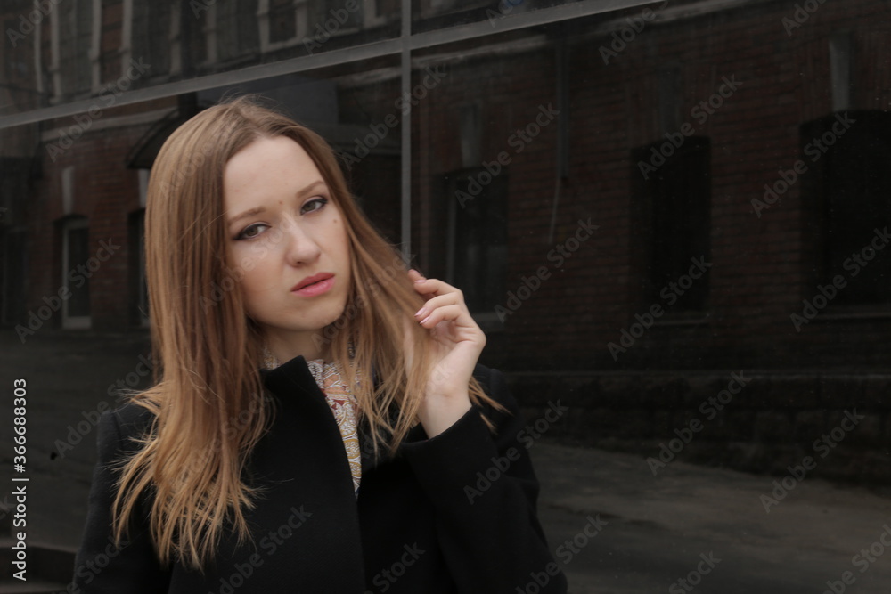 The girl in black coat. Beautiful emotional young girl in the city. Shawl or handkerchief on a person. The girl in black coat. Beautiful emotional young girl in the city. Shawl or handkerchief on a person.