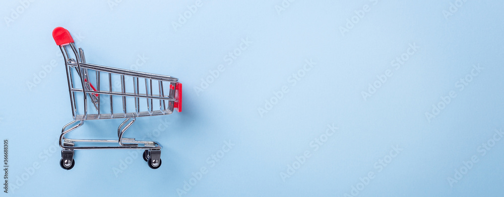 Mini trolley cart copy on blue background. Horizontal banner. Top view Copy space