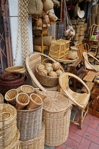 Rows and stacks of rattan weaving materials and furniture displayed on handmade craft store- Chiang mai, Thailand