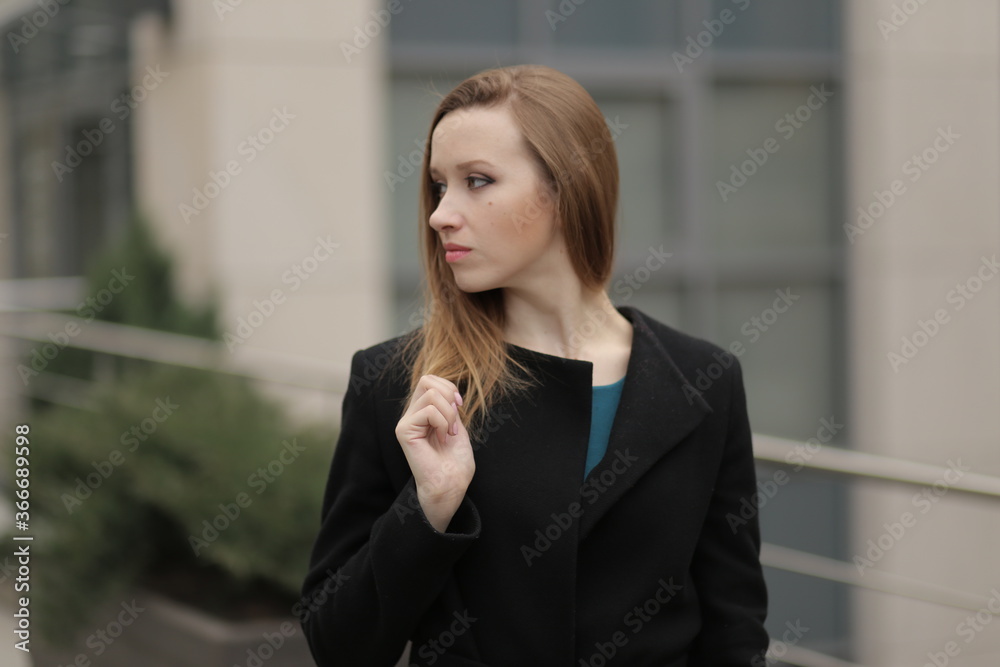 The girl in black coat. Beautiful emotional young girl in the city. Shawl or handkerchief on a person. The girl in black coat. Beautiful emotional young girl in the city. Shawl or handkerchief on a person.