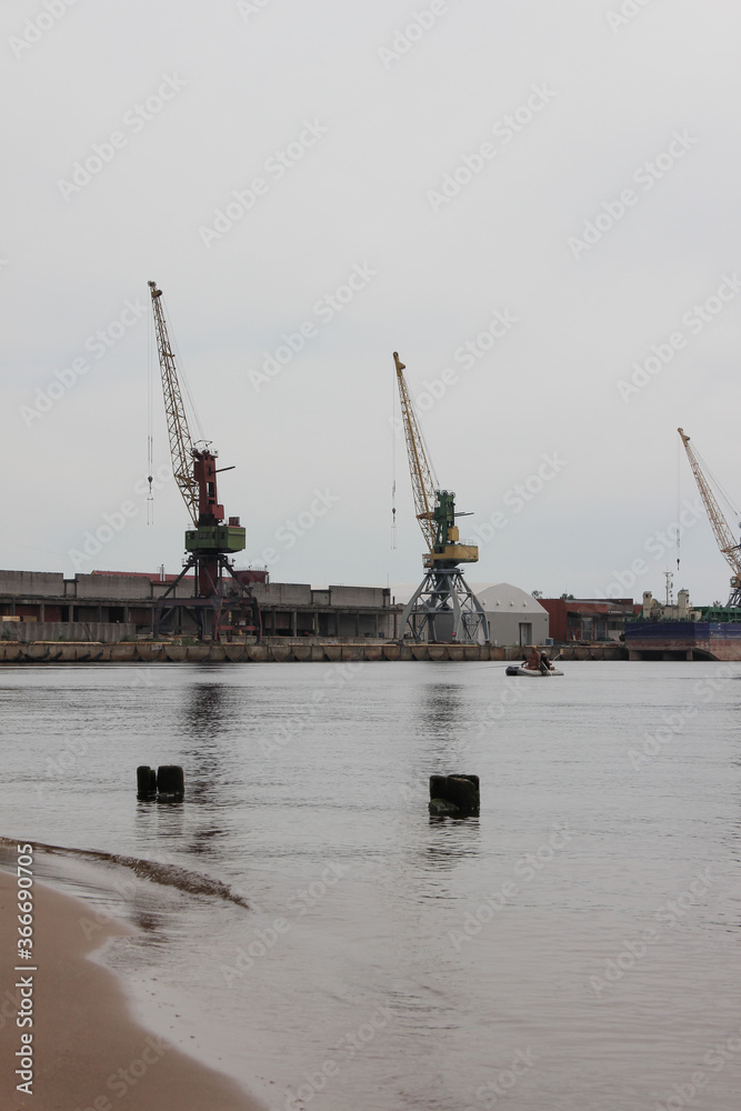 Fototapeta premium Port terminal. View at the deck cranes from ashore.
