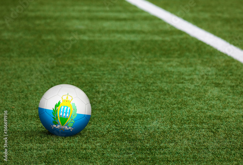 San Marino flag on ball at soccer field background. National football theme on green grass. Sports competition concept. photo