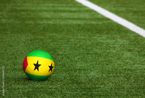 Sao Tome And Principe flag on ball at soccer field background. National football theme on green grass. Sports competition concept.