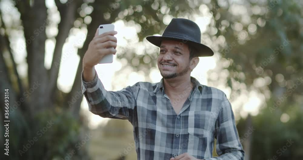 Farmer or country man using a smartphone on the farm. Internet 4G farmer. Social networks, online consultations. 4K.