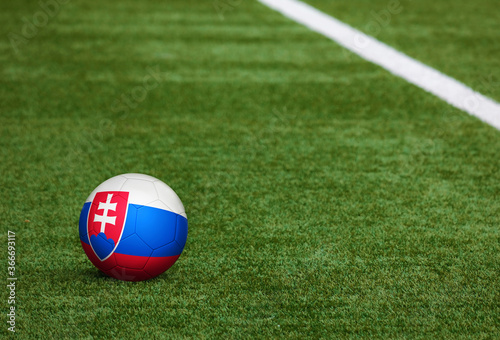 Slovakia flag on ball at soccer field background. National football theme on green grass. Sports competition concept.
