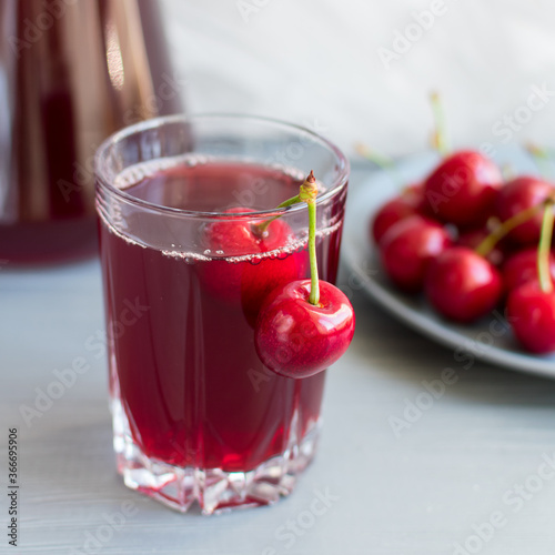 Wallpaper Mural Cherry juice in a glass cup with cherry berries on a plate on a gray table. Selective focus. Torontodigital.ca