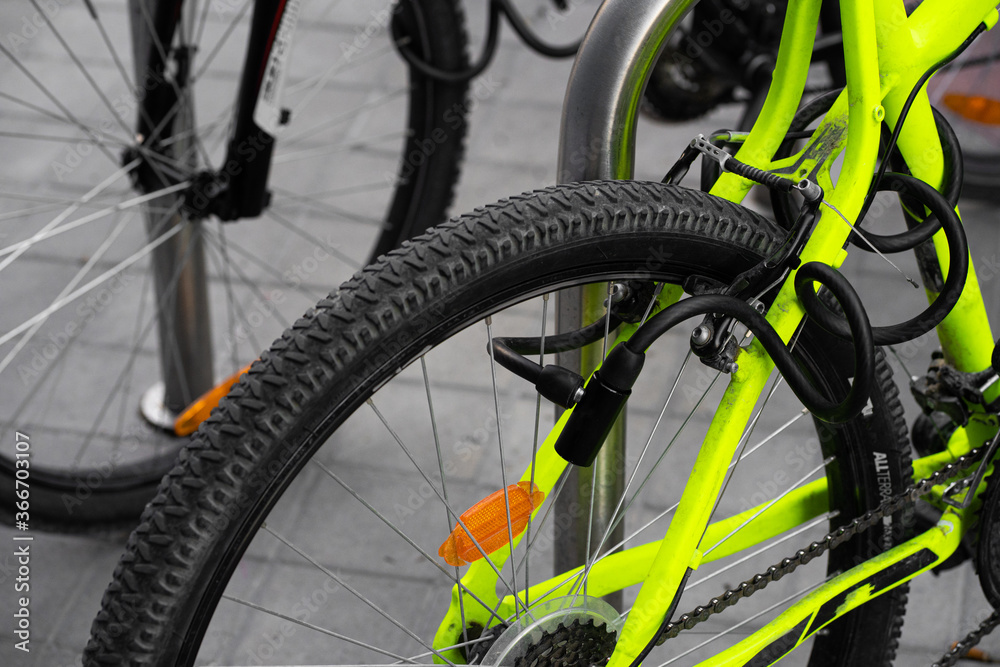 Candado de cadena antirrobo asegurando una bicicleta amarilla fluorescente  foto de Stock | Adobe Stock