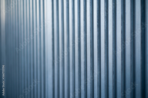 Puerta metálica de pintura plateada metalizada de color azulado, cerrada y vista en perspectiva