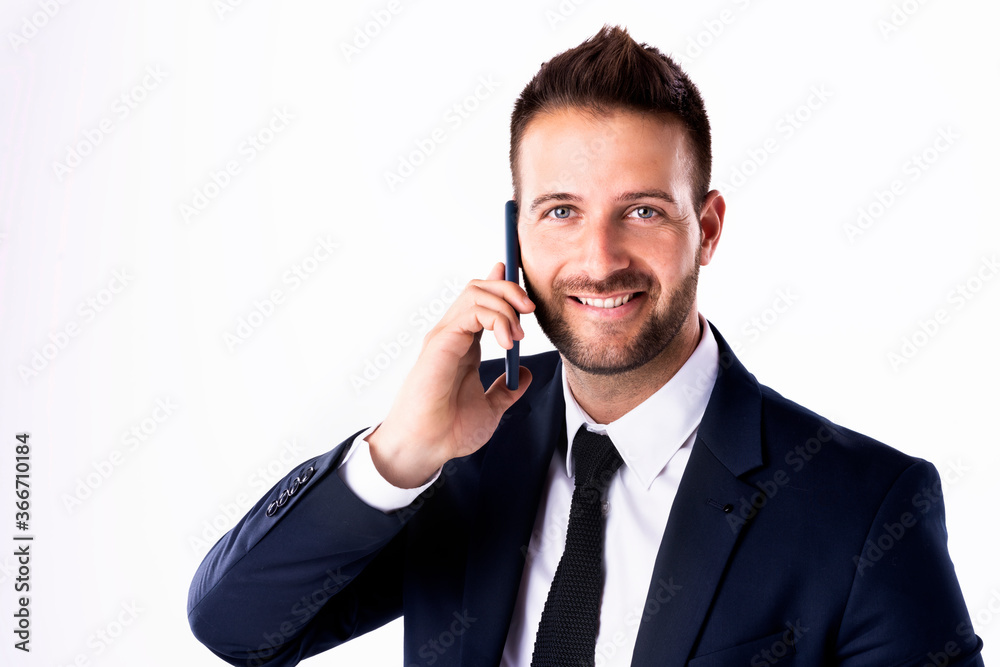 Confident businessman talking with somebody on his mobile phone while standing at isolated white background