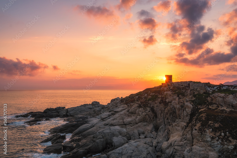 Sun rising behind genoese tower in Corsica