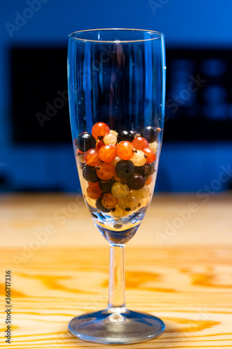 Glass with red currants, black currants and white transparent currants fruit cocktail