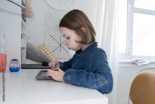 girl at home working on the tablet for school work