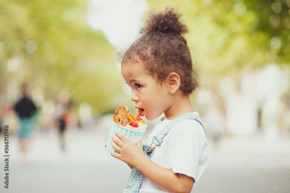 Cute little girl eating ice-cream in the street Cute little girl eating ice-cream in the street