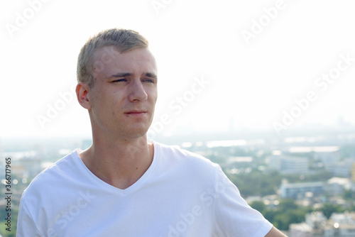 Portrait of young blond man against view of the clear sky