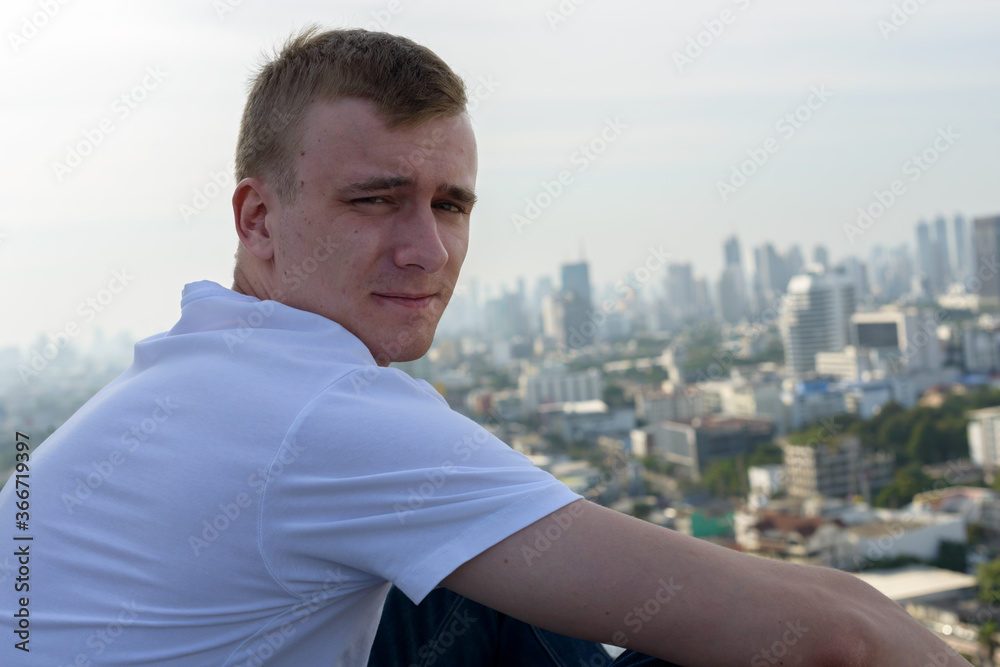 Portrait of young man with blond hair against view of the city Portrait of young man with blond hair against view of the city