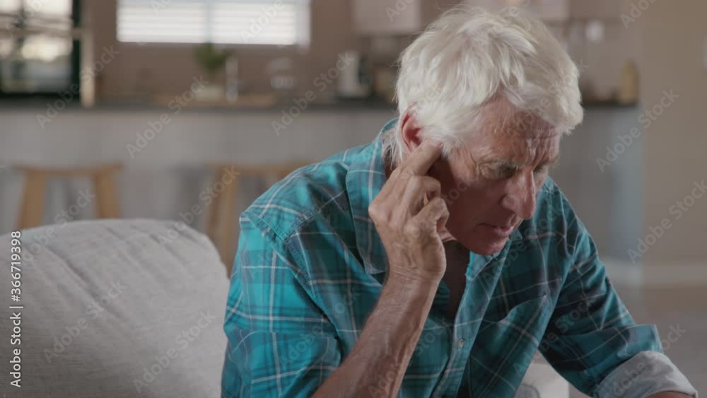 Senior man holding ears while suffering from pain. Tensed mature man sitting at home holding ears. Side view of senior man with symptom of hearing loss, copy space. Mature retired man in pain. Senior man holding ears while suffering from pain. Tensed mature man sitting at home holding ears. Side view of senior man with symptom of hearing loss, copy space. Mature retired man in pain.