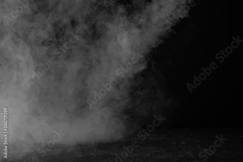 Black concrete background with smoke