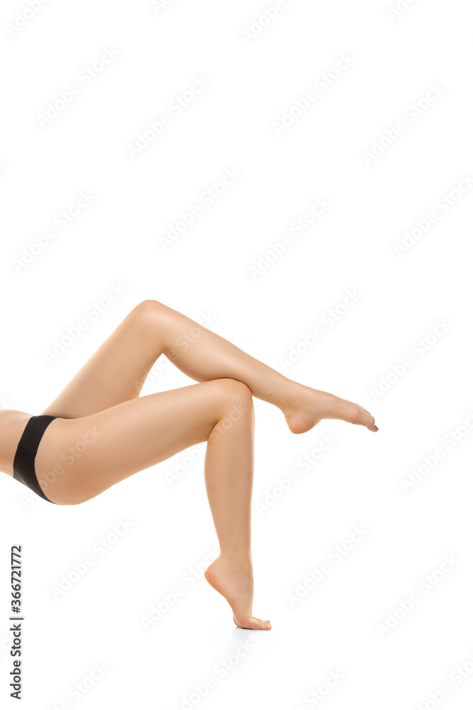 Light. Beautiful female legs, buttlocks isolated on white background. Beauty, cosmetics, spa, depilation, treatment and fitness concept. Sportive, sensual body with well-kept skin in underwear.