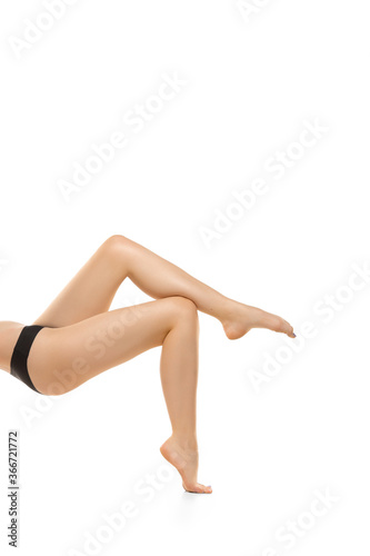 Light. Beautiful female legs, buttlocks isolated on white background. Beauty, cosmetics, spa, depilation, treatment and fitness concept. Sportive, sensual body with well-kept skin in underwear.