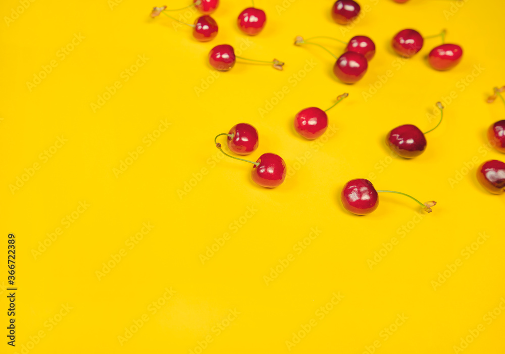 Fresh and organic red cherries on a bright yellow background, healthy living, summer lifestyle Fresh and organic red cherries on a bright yellow background, healthy living, summer lifestyle
