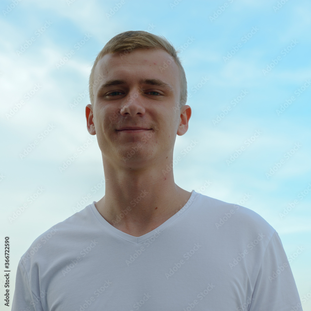 Portrait of young blond man against view of the clear sky