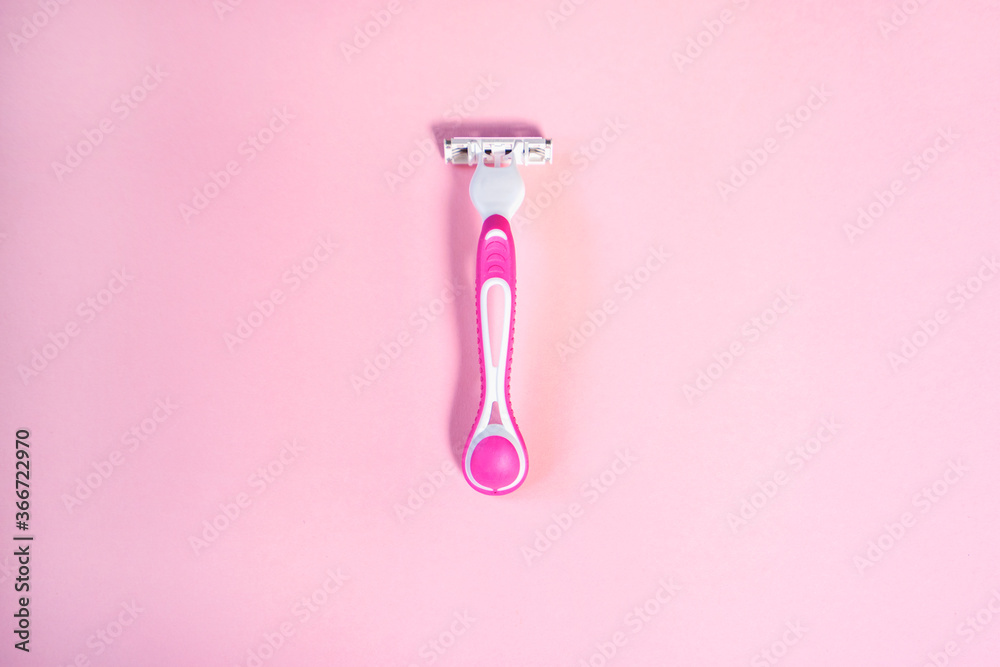 Pink razor for shaving on a light pink background Pink razor for shaving on a light pink background