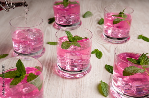 Glasses with pink drink  with ice and boil good on wooden table