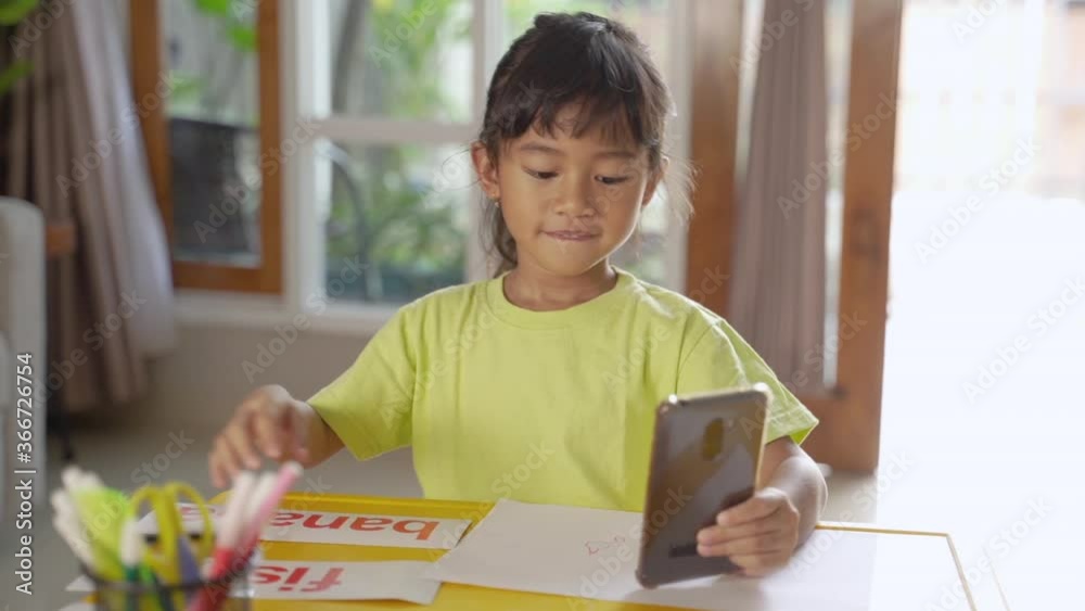 little girl studying from home during self isolation. learning using conference call via smartphone little girl studying from home during self isolation. learning using conference call via smartphone