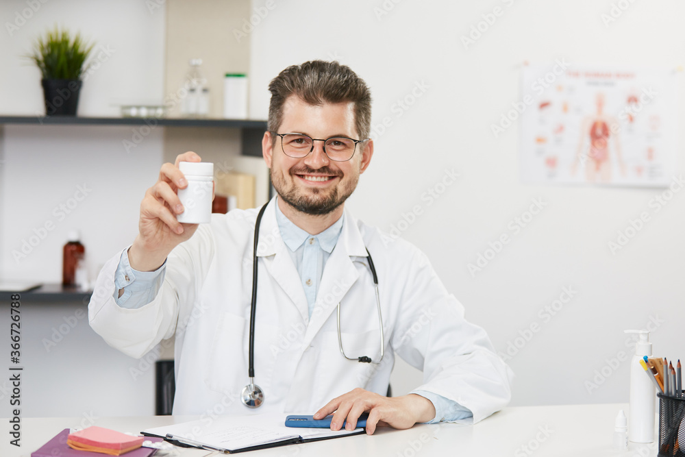 doctor holding jar of tablets and smiling to camera doctor holding jar of tablets and smiling to camera