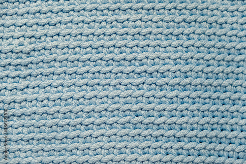 Light soft blue knitted fabric texture background. Top view. Copy, empty space for text