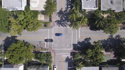 Aerial footage of Miami South Beach Crossroad in urban area where Police car and other Cars Drive through 