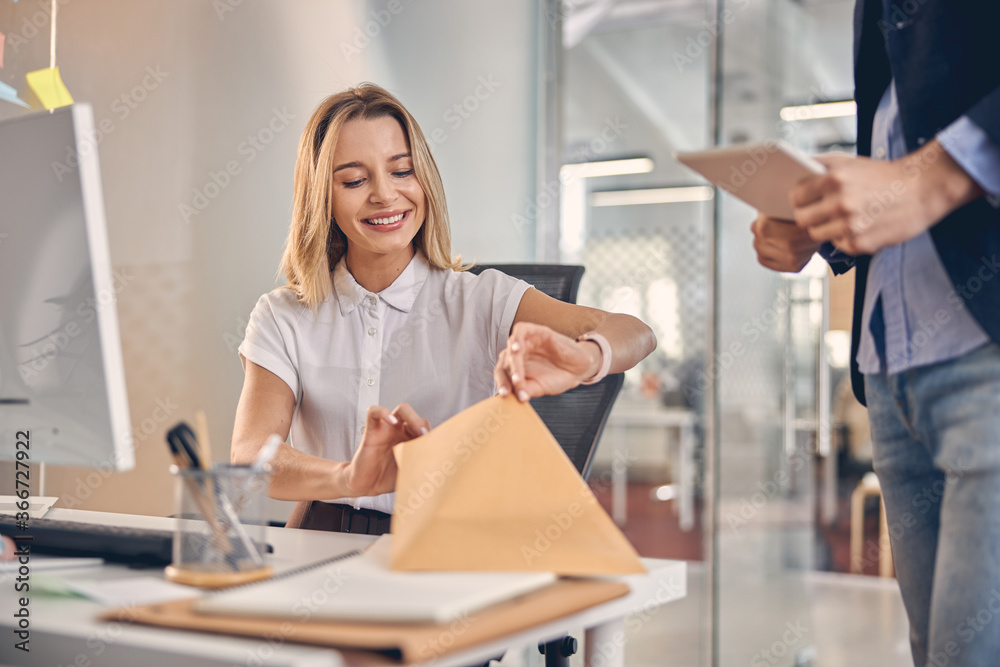 Cheerful young woman checking documents at work Cheerful young woman checking documents at work