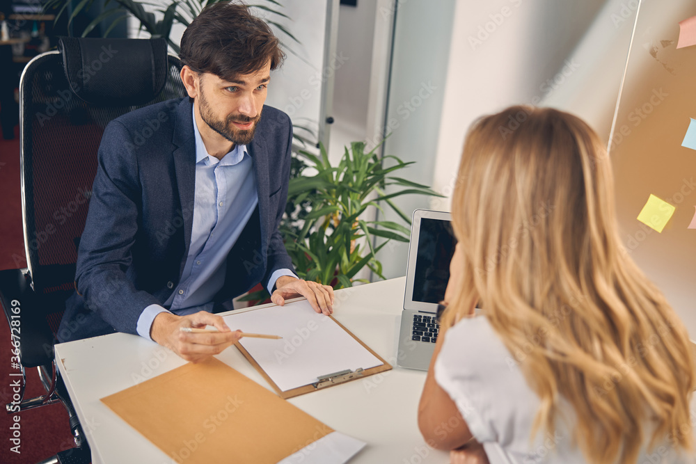 Handsome young man discussing contract with business colleague Handsome young man discussing contract with business colleague