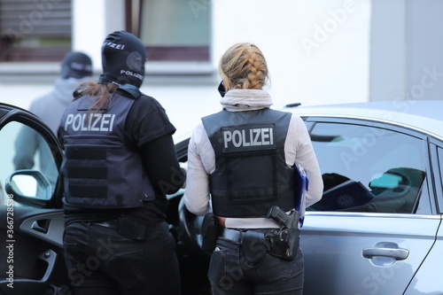 Zwei Polizeibeamtinnen im Einsatz bei einer Razzia photo