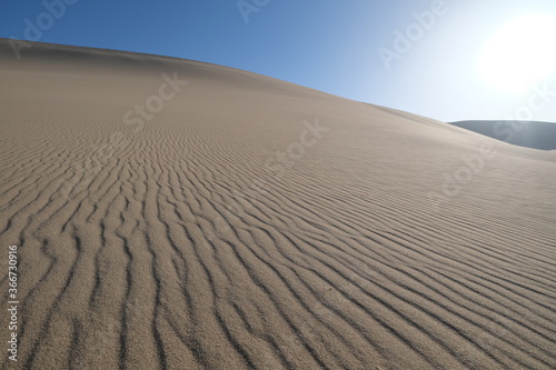 low angle of wide sand dune under sunshine. At Dunhuang, Gansu province, China