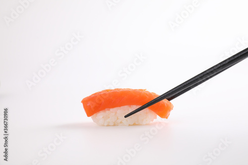 Salmon sushi with chopsticks Japanese food isolated in white background