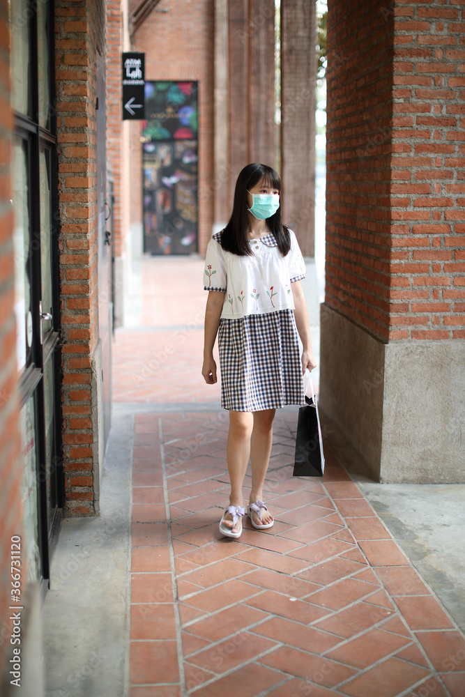 Portrait young woman with mask shopping at community mall on urban in covid-19 virus outbreak Portrait young woman with mask shopping at community mall on urban in covid-19 virus outbreak